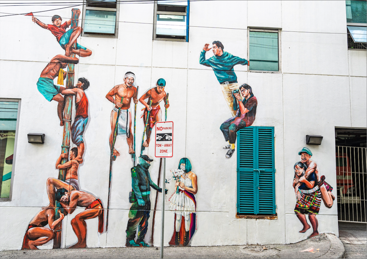 streat mural of people looking and on stilts